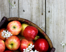 A basket of red apples and white flowers.